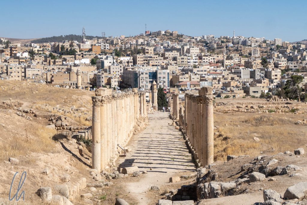 Blick über den historischen Decumanus zum modernen Jerash.