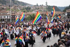 Eine indigene Gruppe in der Parade mit ihrer Regenbogen-Flagge