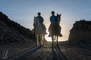 Pferde und Reiter im Abendlicht: Mona auf Machi, Christian auf Clavel